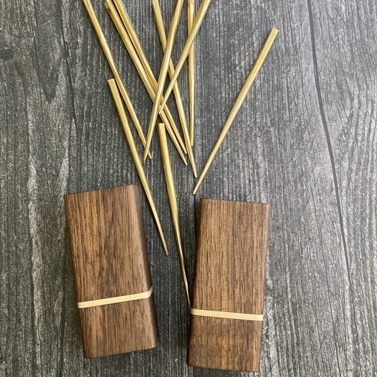 A beautifully crafted set of forged brass cocktail picks in an ebonized walnut and brass holder from The Dustworks