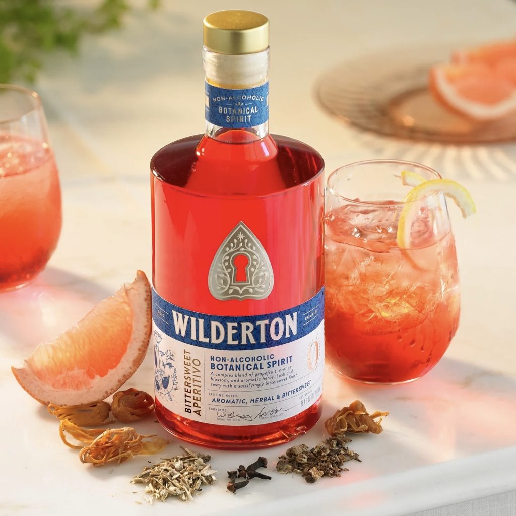 A bottle of Wilderton non-alcoholic spirit on a counter with botanicals