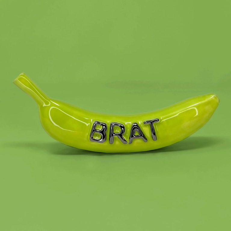 A green ceramic banana with the word Brat on it