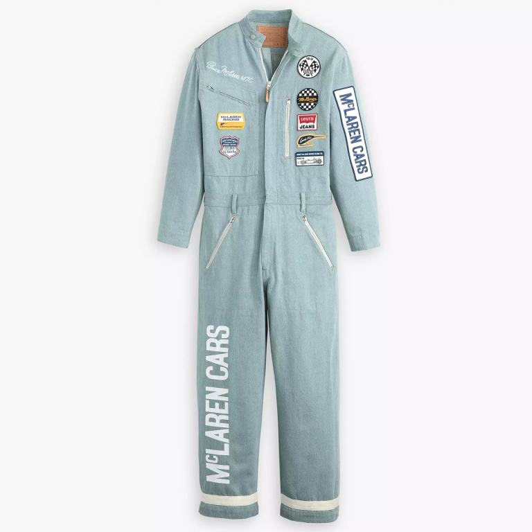 A light denim jumpsuit with McLaren Racing patches on it