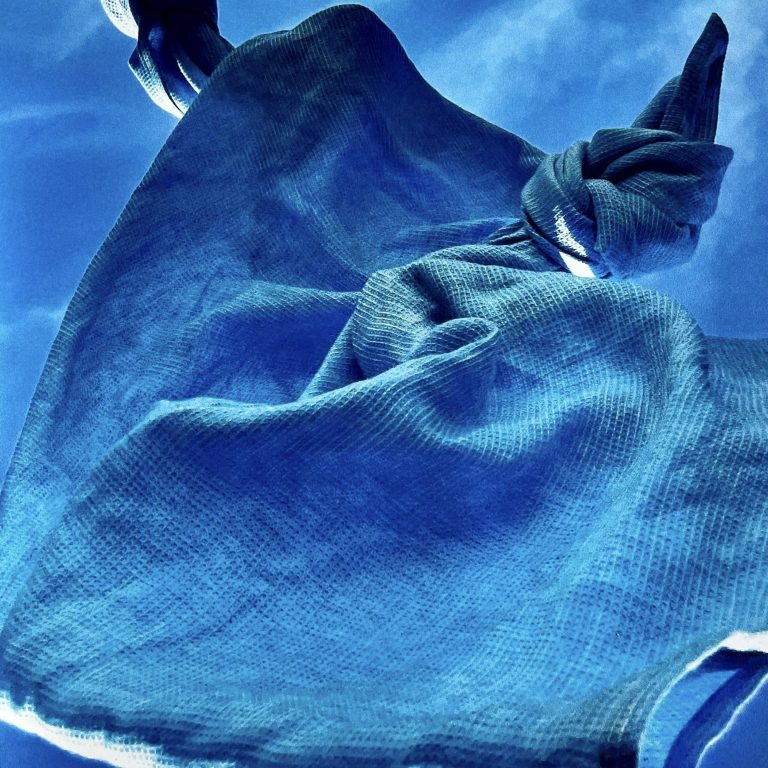 A blue Grid Linen towel against a blue sky