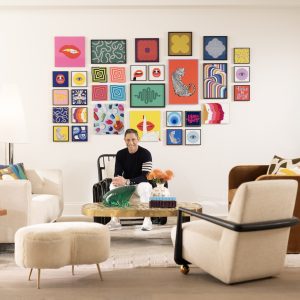 Jonathan Adler seated in front of many art works in his new Tilepix collaboration